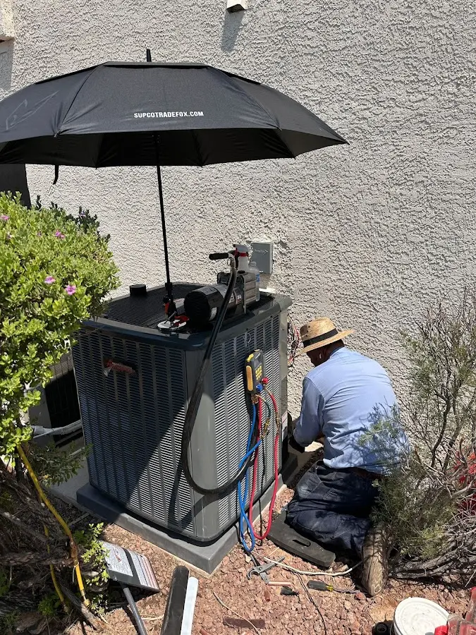 HVAC technician performing outdoor AC maintenance in Great Barrington